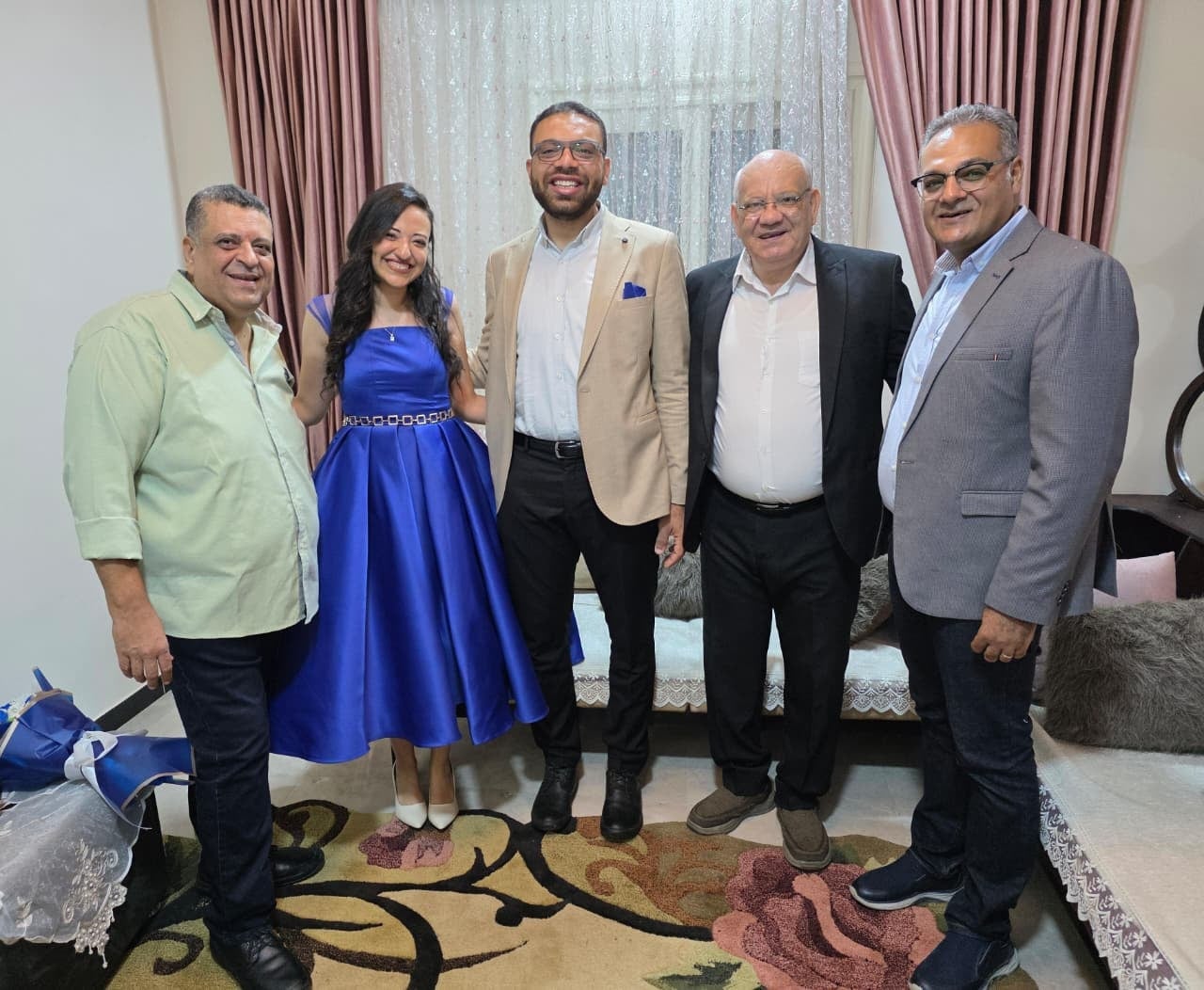 Nada and John standing with family in the living room on their engagement day