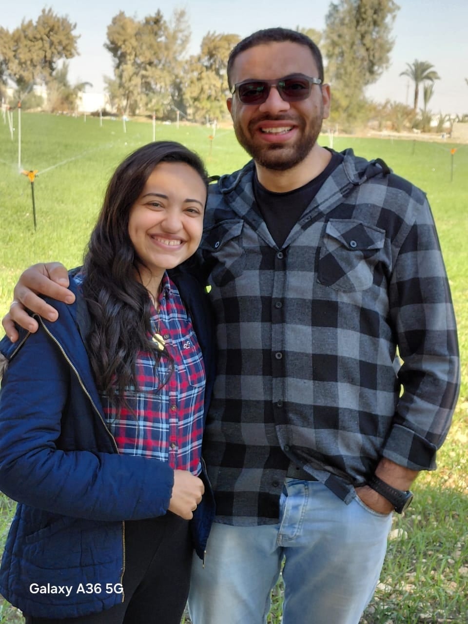 Nada and John on a sunny lawn, his arm around her