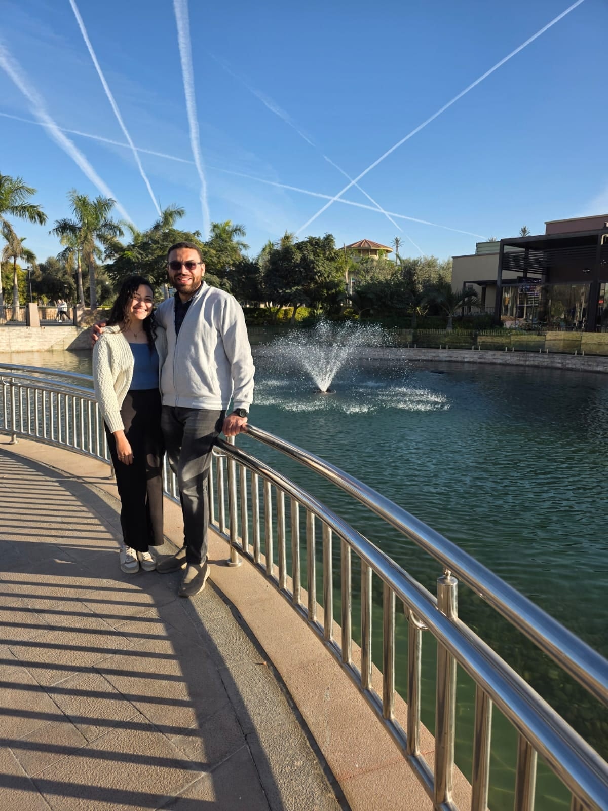 Nada and John on a bridge beside a fountain