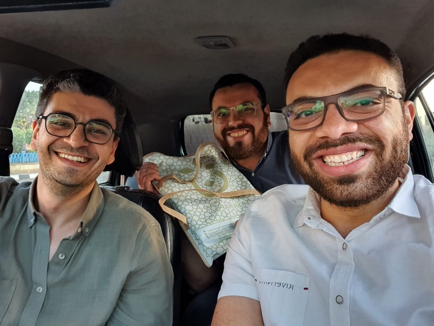 John and his friends on the way to propose, smiling in the car